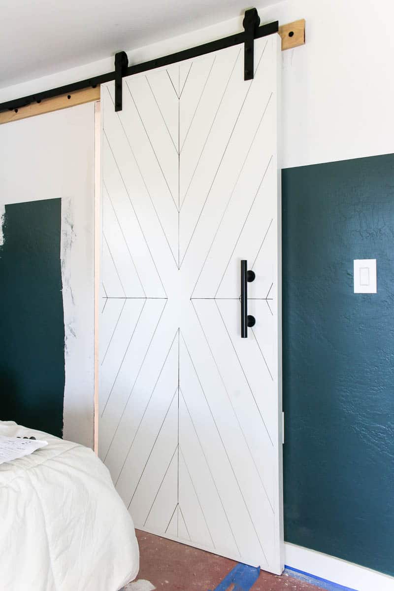 This white wood sliding barn door is a perfect modern farmhouse style accent for any home. We've hang it in our bedroom as a sliding master bathroom door.