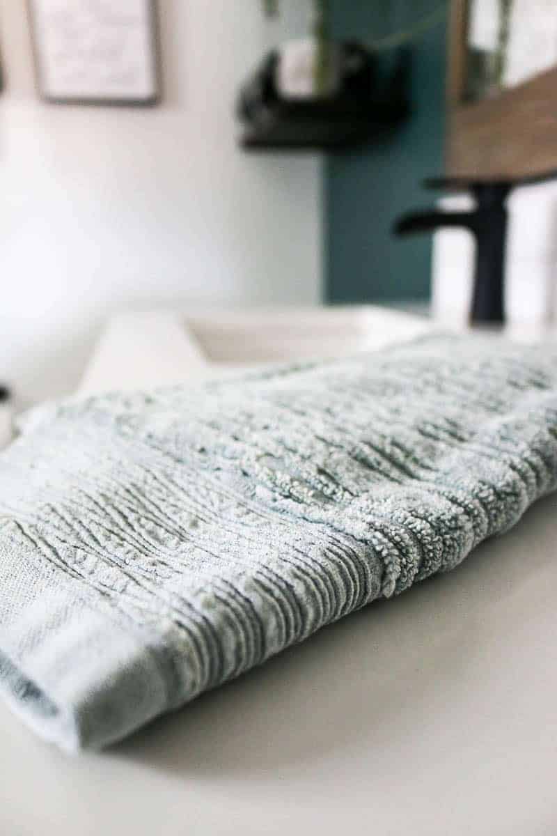 Light green textured hand towels in bathroom on vanity counter up close shot