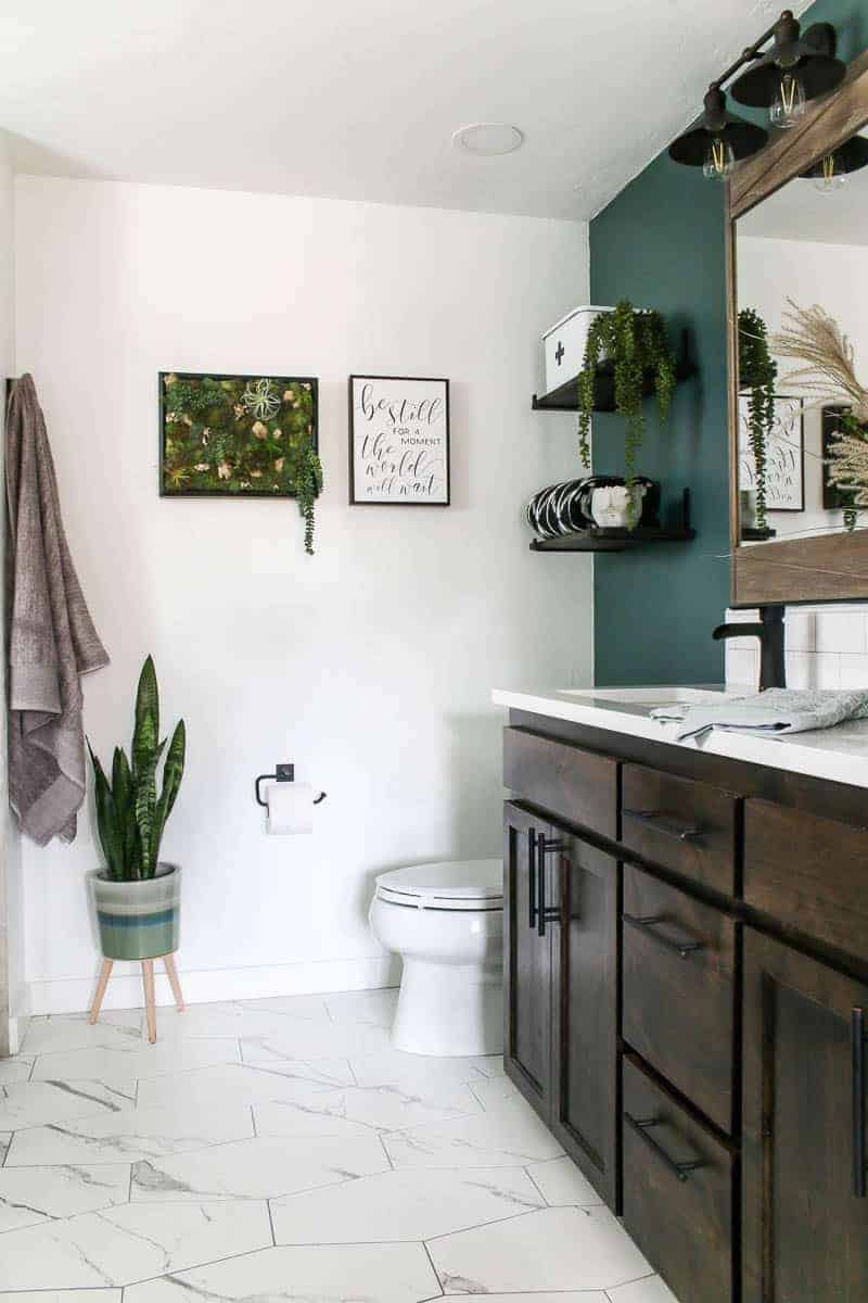 side of bathroom featuring vanity area with floating shelves and wall decor