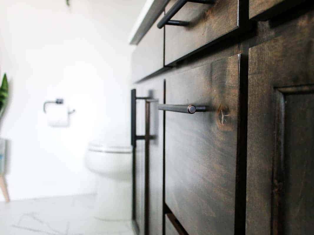 Close up shot of wooden vanity drawers in master bathroom with oil rubbed bronze drawer pulls