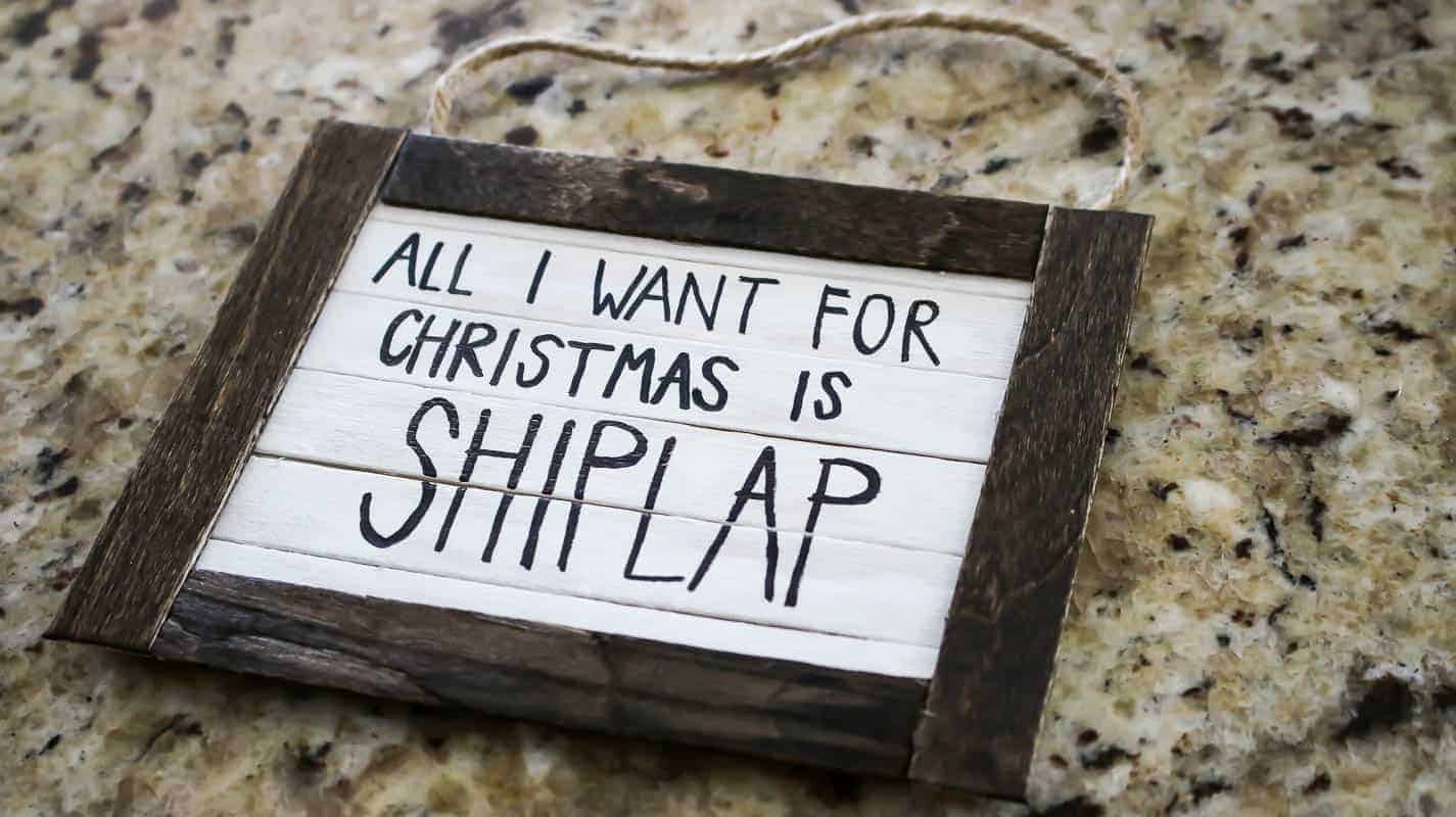 Finished project of the handmade Christmas ornament with text inside that says All I Want For Christmas is Shiplap