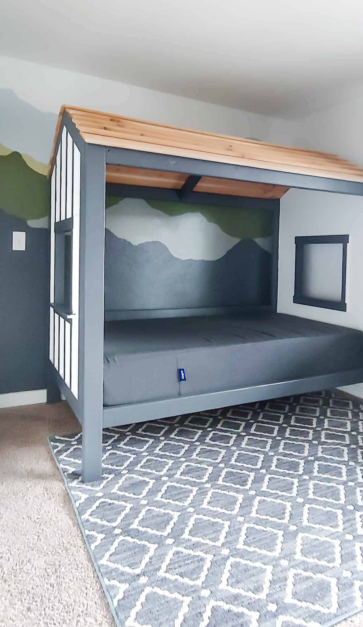 This DIY kids cabin bed is perfect for a camping themed room for your kiddo's first big kid bed.