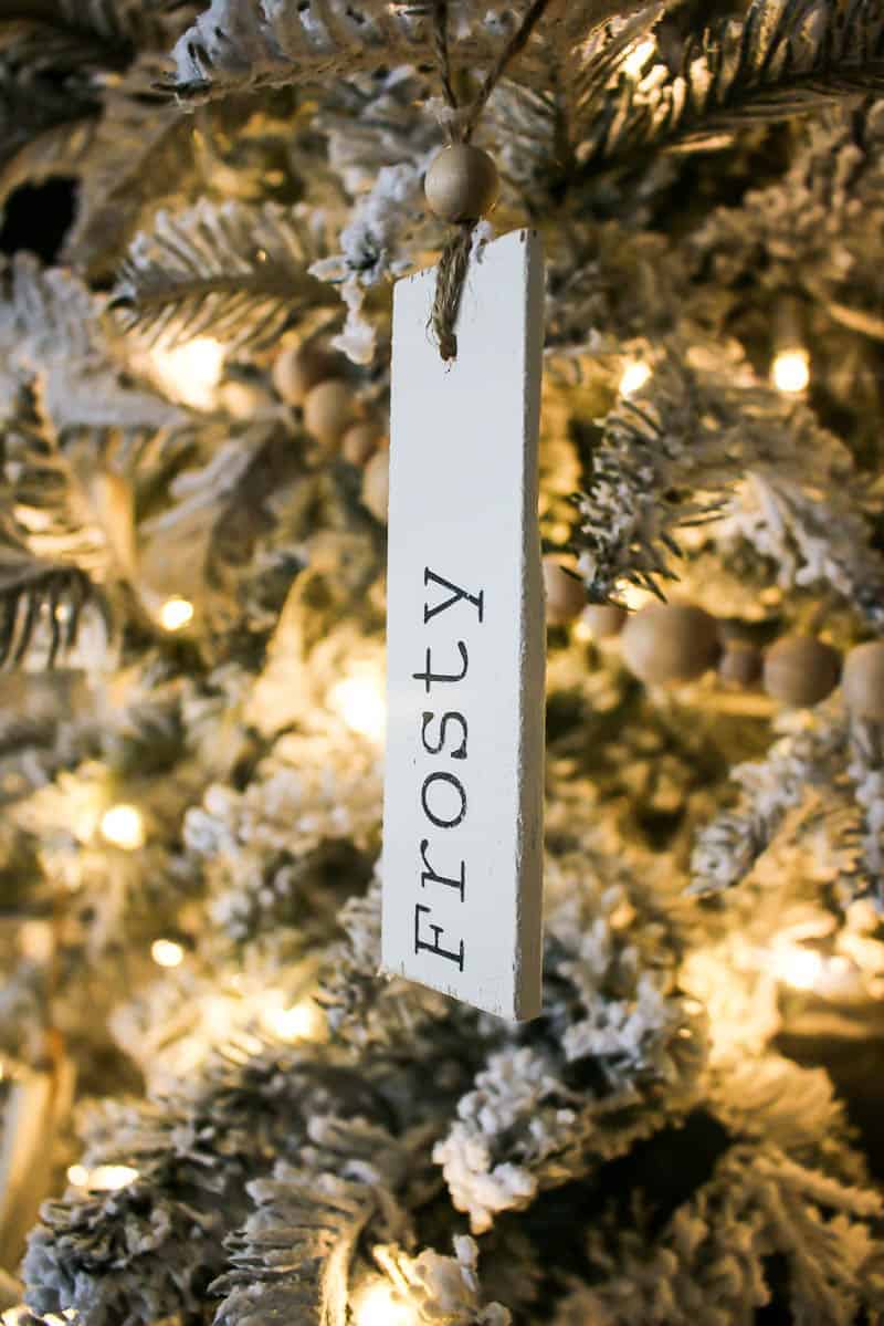 Closer look of the wooden ornament  with 'Frosty' engraved hanging on the Christmas tree