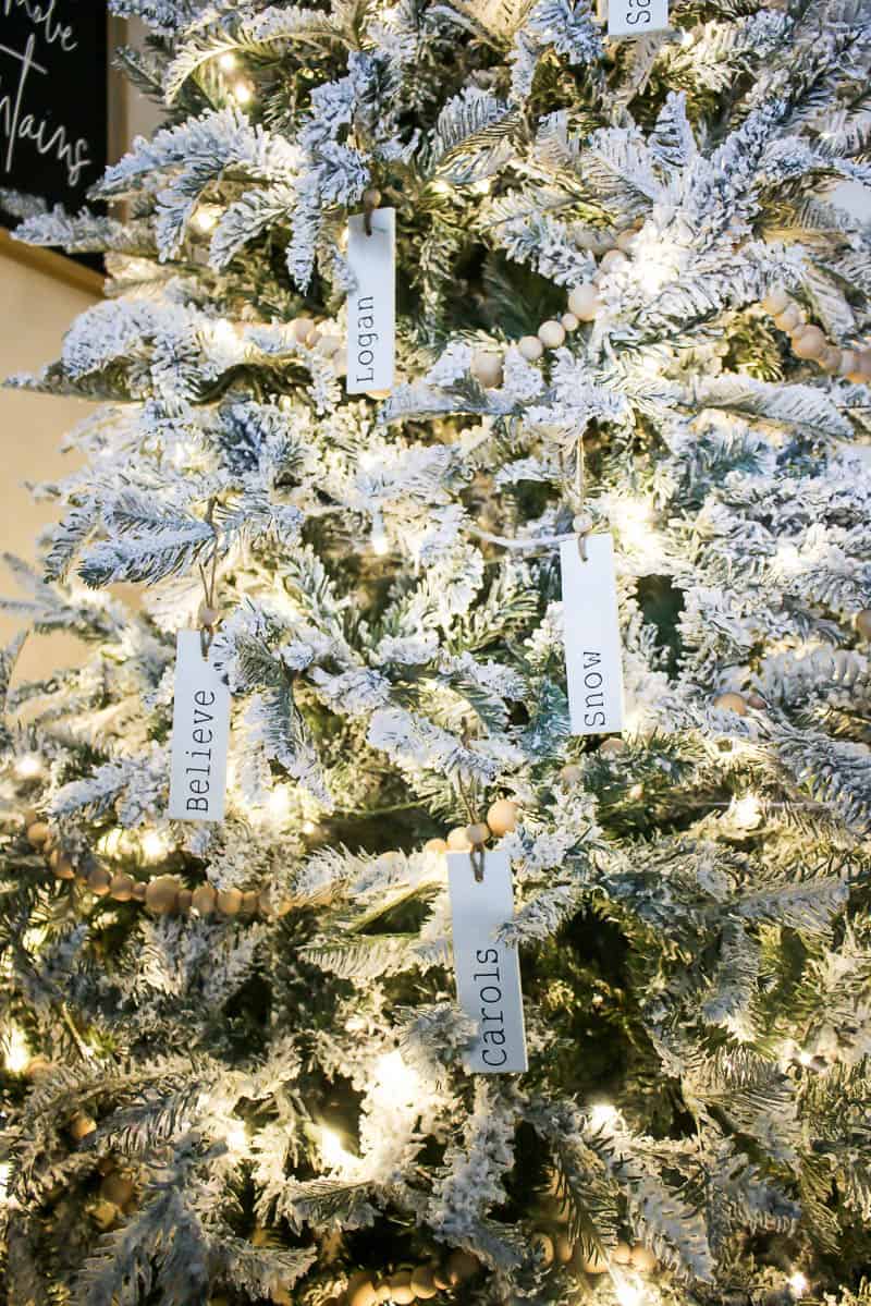 Wooden personalized ornaments hanging on the flocked Christmas tree