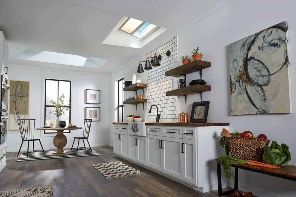 Modern boho kitchen with dark wood floors, white cabinets, wood counter tops, and black accents. Along with open shelving and tile backsplash above the sink.