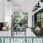 Modern White kitchen with white cabinets, floors and walls with black accents and counter tops and a skylight. Text Overlay Says "7 Reasons to Add Skylight"