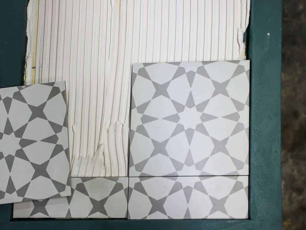 Placing tiles on the side if the DIY laundry hamper using tile adhestive