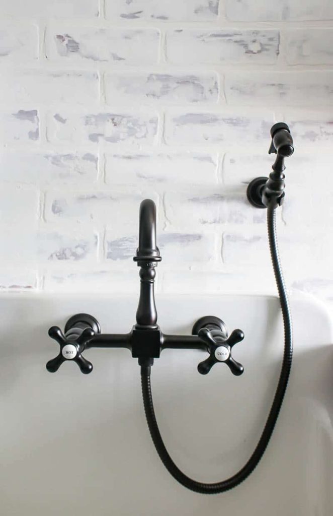 A vintage inspired wall mount faucet in a farmhouse laundry room sink