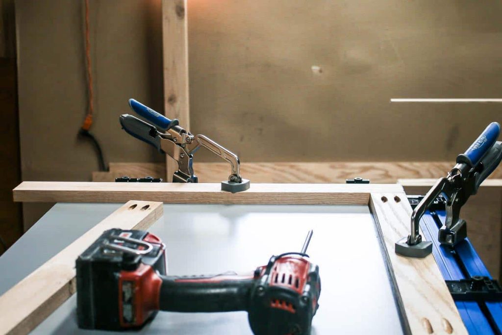 A photo of a Kreg clamp in use to create a sink cabinet for the laundry room.