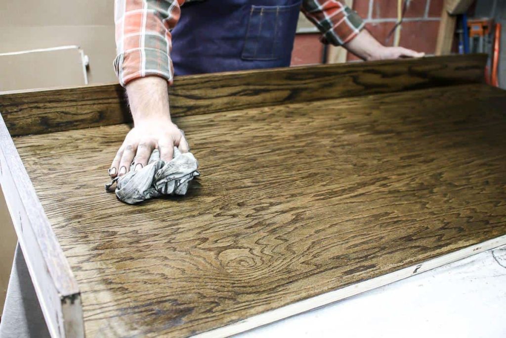 Then he stains and seals the wood of the cabinet.