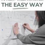 A person pinning the stencils to a white wall over a sin with text overlay that says learn how to create wall stencils the easy way