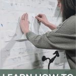 A person pinning the stencils to a white faux brick wall over a sink. On bottom it says learn how to stencil on the wall