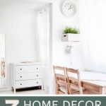 shows a white room with a white cabinet and wood table and chairs with a white box planter on the wall. With texts that says 7 home decor blogs you should be following