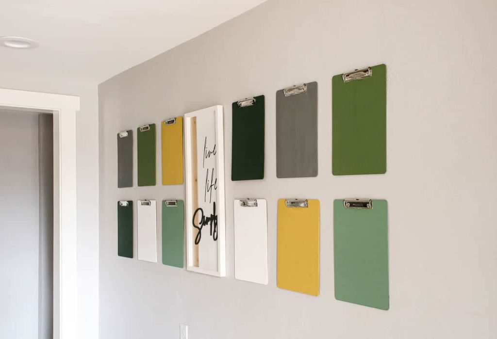 coloful clipboard hanging on a wall, to make a fun clipboard gallery wall