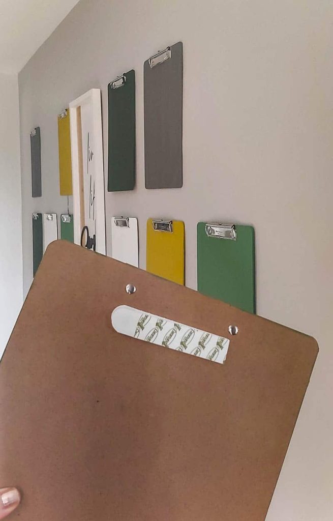 Photograph showcasing clipboards secured to a wall using Command strips, offering a practical and visually appealing solution for office document management.