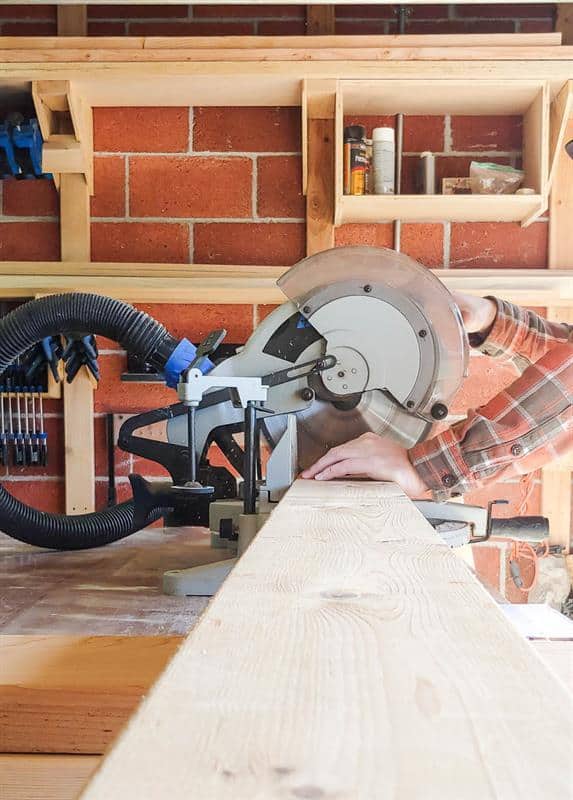 Using a miter saw, the wood is being cut to create the tabletop for a kitchen table.
