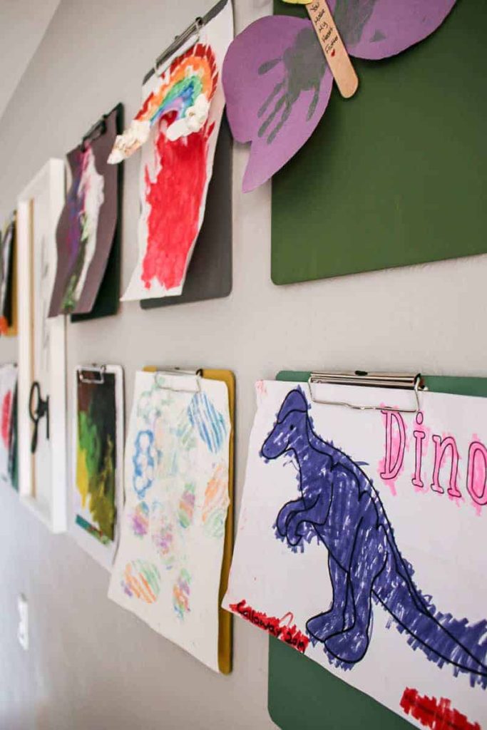 shows the colorful clipboards with kids paintings and drawing hanging from them