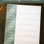 Shows a weekly schedule on a dark wood table with overlay text that says free download cleaning schedule