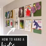 shows 12 clipboards with kid's paintings hanging from them on a gray wall with a live life simply frame hanging in between them with overlay text that says how to hang a kid's art gallery