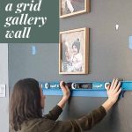 shows a woman using a level on a gray wall and marking where she is gonna hang photos in a wood frame with overlay texts that says tips for hanging a grid gallery wall