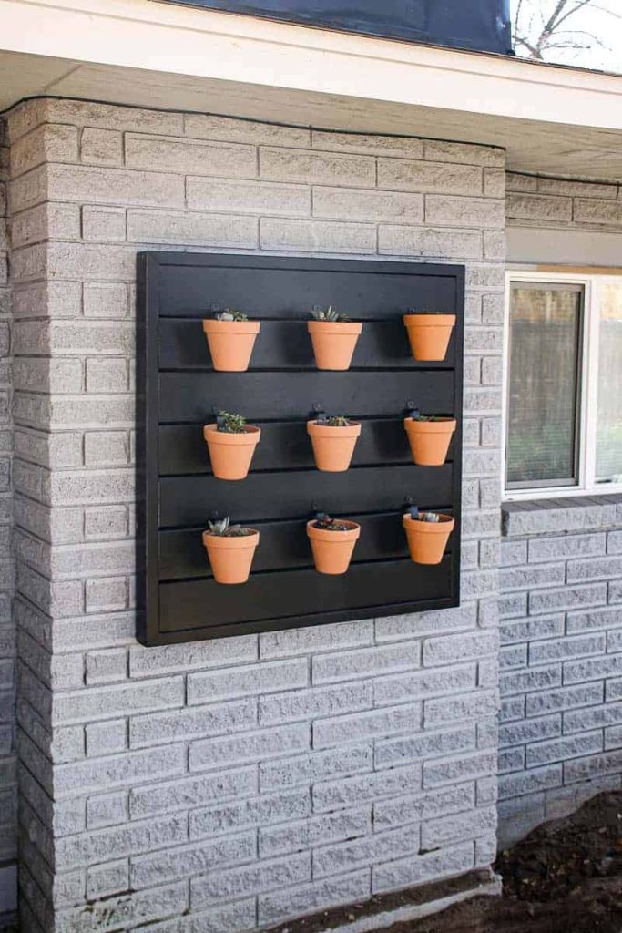 Here's an easy tutorial that shows you how to make a hanging planter wall that can hold up to 9 terra cotta planters