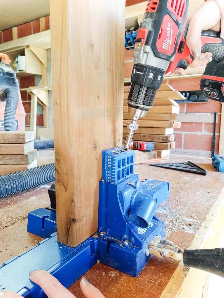 shows a drill drilling in a screw into a vertical standing wood held in place by a Kreg K5 pocket hole system