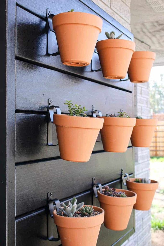 This hanging planter wall looks great with rows of terracotta planters