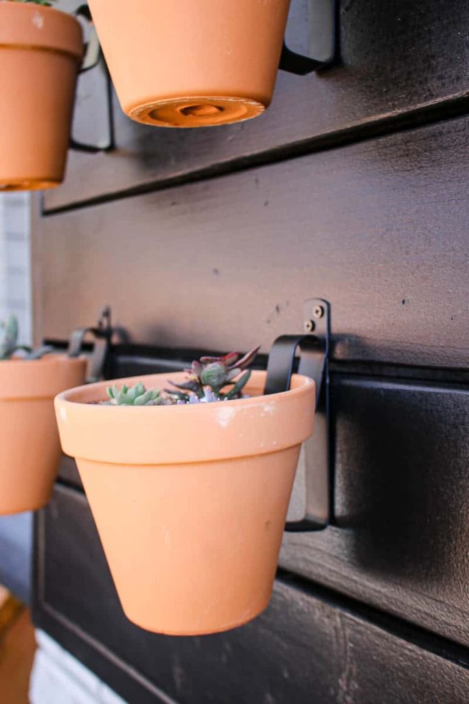 A close up image shows how these terracotta pots are attached to the hanging planter wall with clips