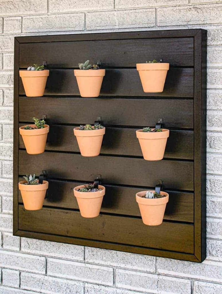 A diy outdoor wall planter made with terracotta planters is perfect for a creative backyard garden space