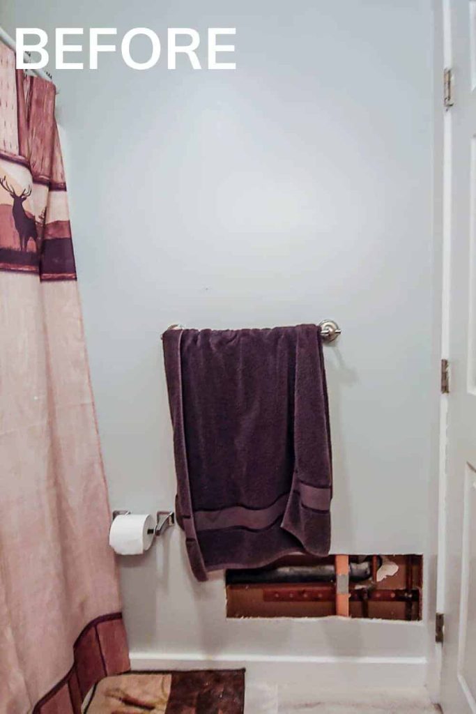 A plain bathroom wall with an installed towel rack and large hole cut in the wall from a sink installation. We plan to install vertical shiplap on this wall.