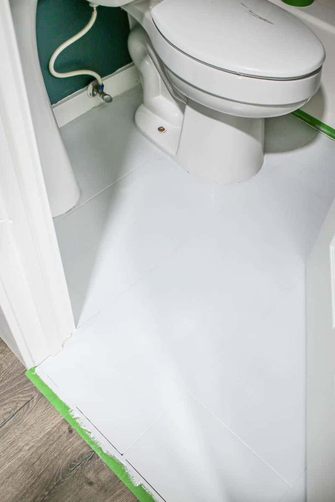 A fully applied white base coat of tile paint applied to the bathroom floor. ready for stenciling floor tiles