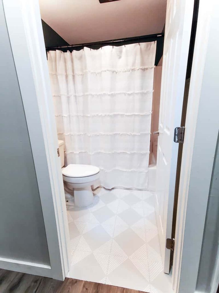 Our completed guest bathroom with new decor and completed tutorial about stenciling floor tiles
