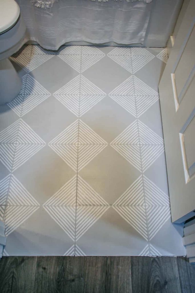 An overhead view of the newly painted tile floor with white and gray geometric stripes