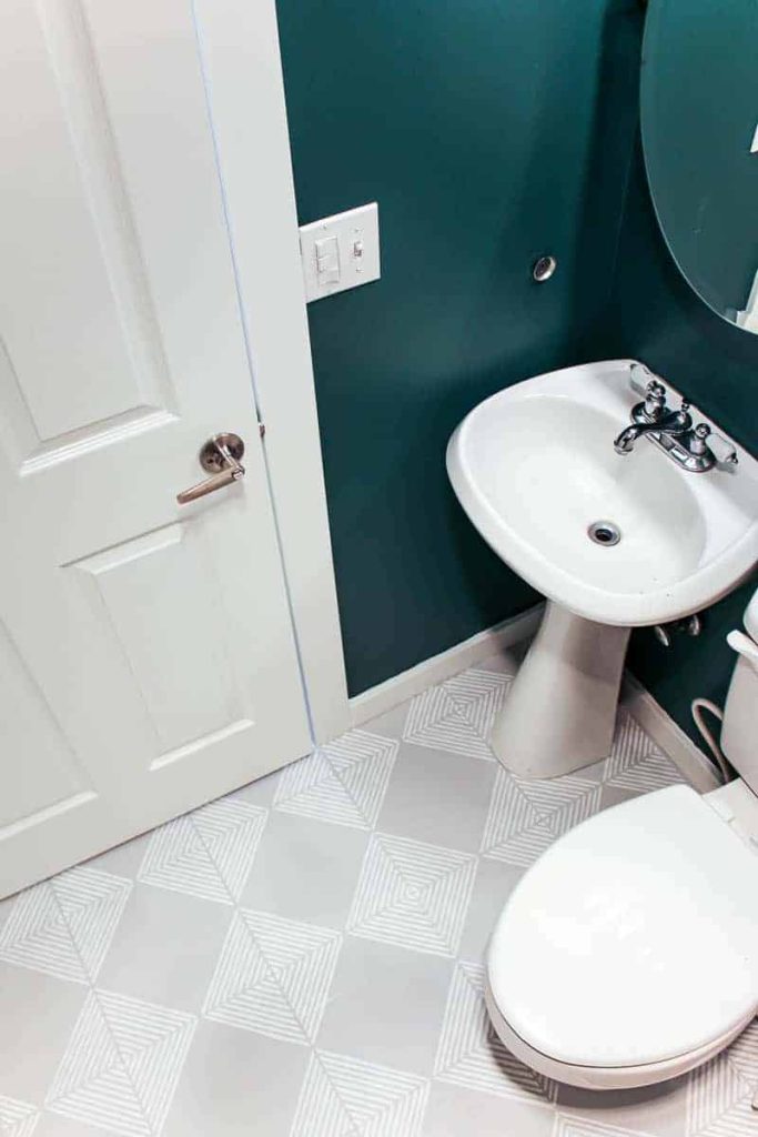 An overhead look at the painted tile floor in our guest bathroom, with white and gray striped tiles