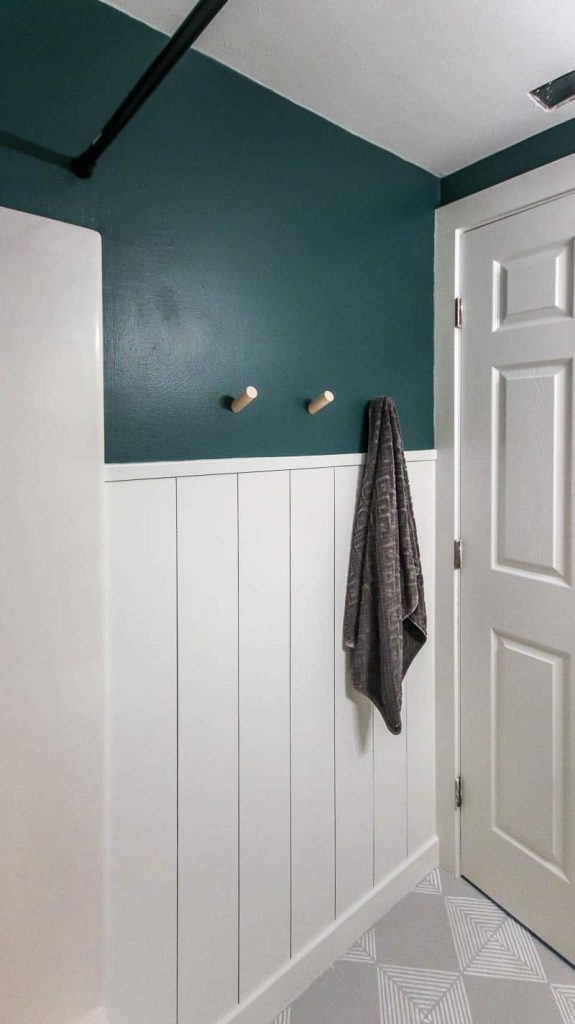 A look at our completed vertical shiplap wall in the bathroom; half of the wall is painted white and the top half of the wall is painted teal.