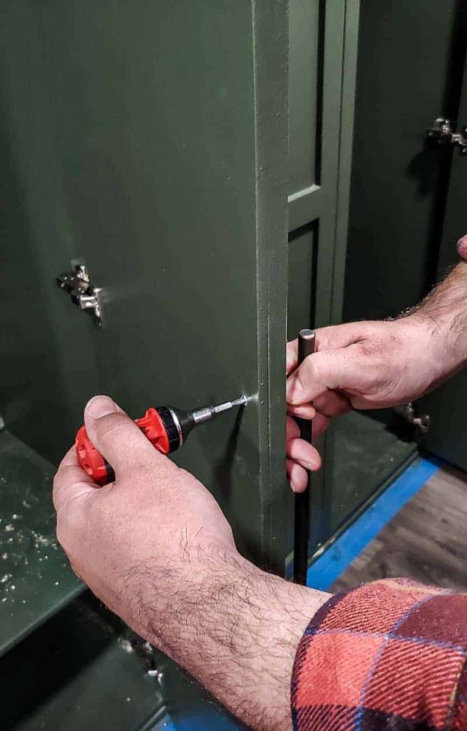 shows hands screwing in the handles on the outside of the mudroom lockers