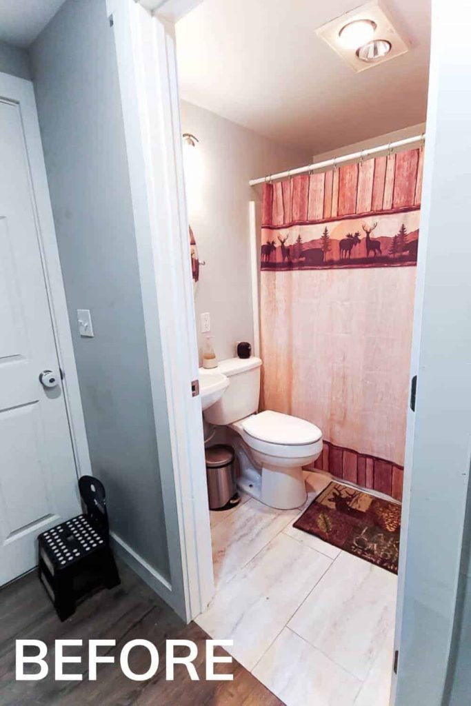 A small and outdated guest bathroom with tan tile and a cabin-themed shower curtain