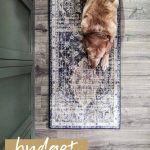 Yellow lab dog laying on a vintage inspired boho runner rug on gray floors with text overlay that says budget boho runner rug