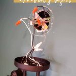 shows a dark teal bathroom with a hold in the wall with multiple wire sticking out with a vanity light attached with overlay text that says how to install a vanity light, watch now