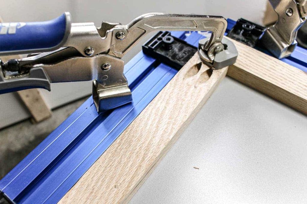 Edges of the wood being attached with pocket hole joinery held down on a clamp table