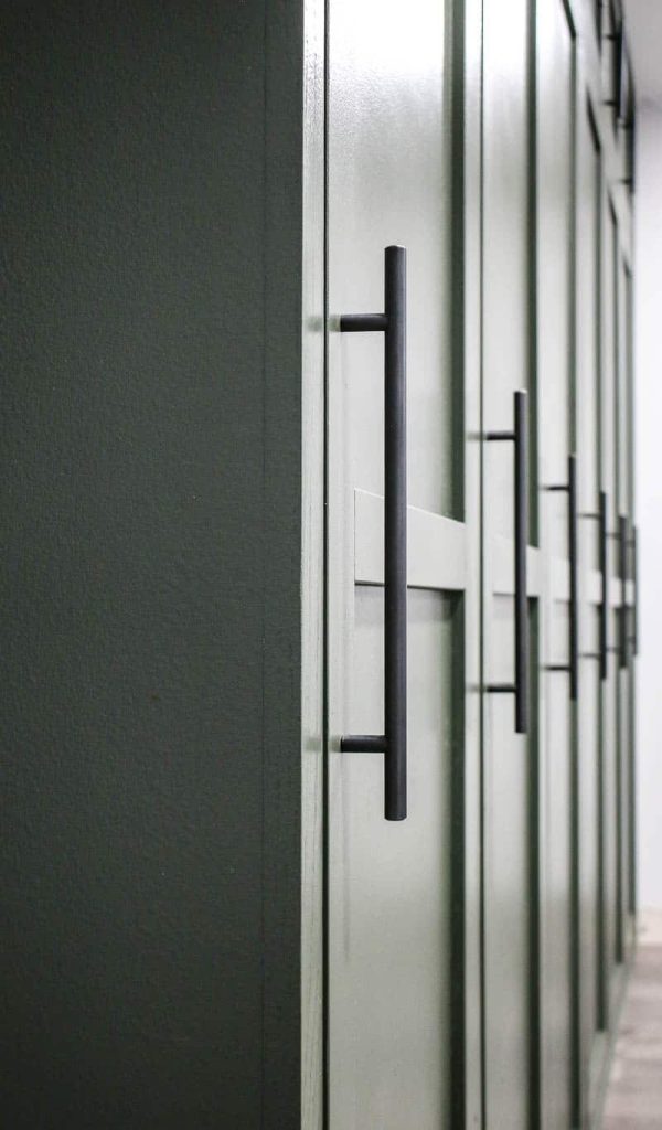 shows a closer up view of the green mudroom locker doors with oil rubbed bronze pulls