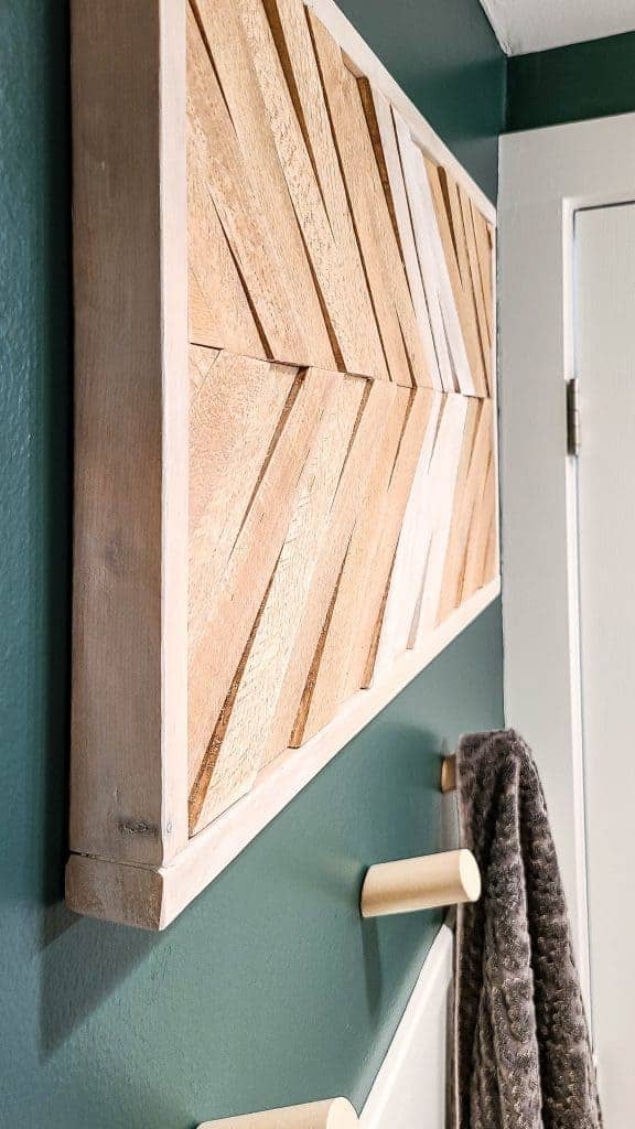 A closer look at the DIY wood wall art we made of our updated guest bathroom makeover shows the raised texture and different colors of wood.