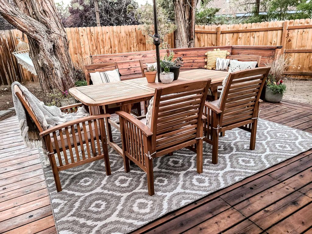 Our new Acacia wood table and chairs perfectly matches our backyard deck. The chairs are accessorized with tan cushions and stylish throw pillows and blankets.