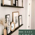 shows another angle of the dark stained ledge shelves with upcycle frames on a gray wall in a hallway with overlay text that says easu ledge shelf (free plans!)