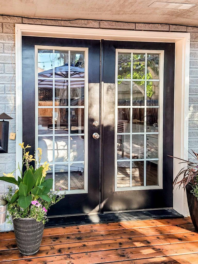 Part of our cozy patio makeover was painting our double Fresh doors black and add planted on either side of the doors.