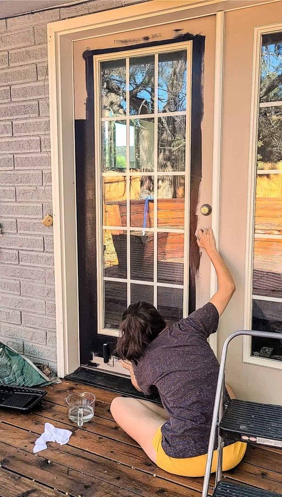 As part of our cozy backyard patio makeover, we painted the double French patio doors black with a durable semi-gloss exterior paint.