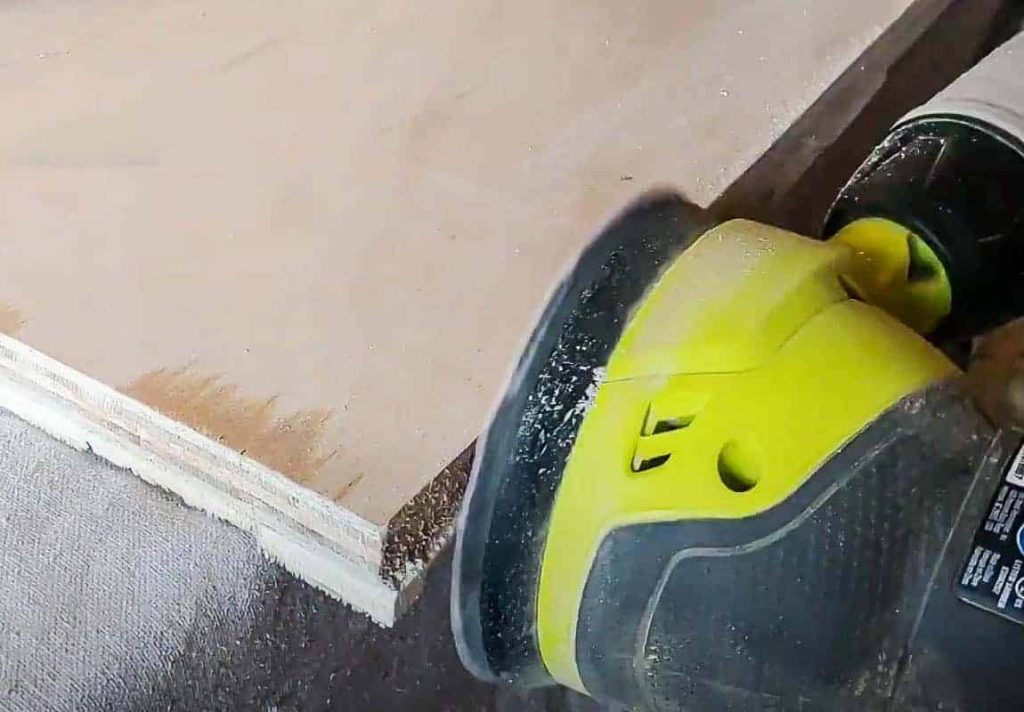 shows an orbital sander sanding the sides of plywood on the DIY wood wall art