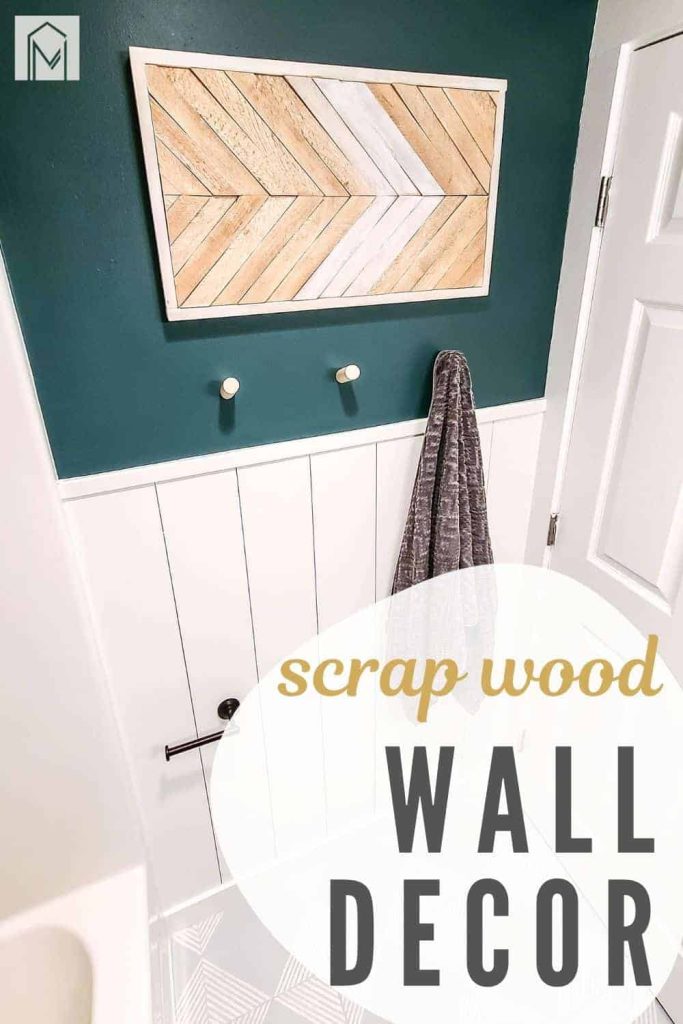 Boho wall decor with wood shim arrow pattern on wall in bathroom above towel rack with text overlay that says scrap wood wall decor