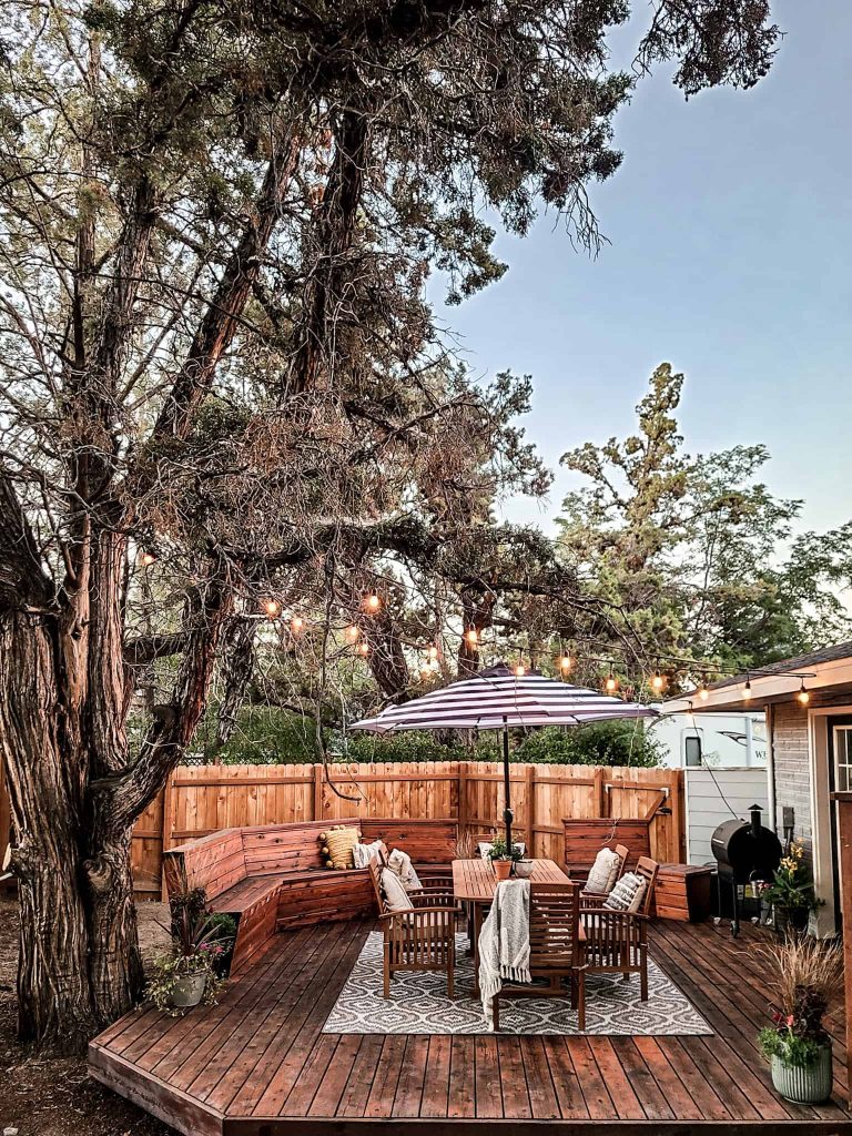 Our new cozy patio space is complete with a new dining table and chairs, new rug, and string lights hanging overhead.
