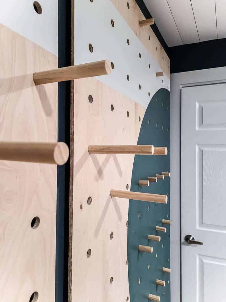 Long and short dowel rods installed in various positions on our giant pegboard wall, where we'll be installing shelves for organization.